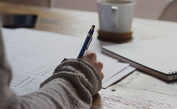 a person sat writing at a desk